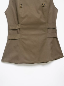 Detail of khaki peplum vest top showing tortoise buttons and waist webbing trim