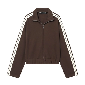 Detail of dark brown zip-up sports jacket featuring white stripes on sleeves and high collar