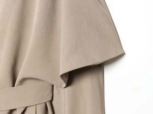 Detail of soft khaki trench coat featuring wide cuffs and elegant waist tie closure