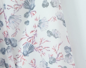 Detail shot of ocean shell and coral floral print on lightweight white chiffon fabric
