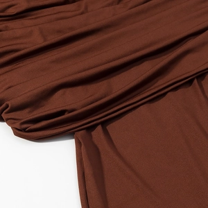 Macro shot of caramel brown pleated fabric with silky satin texture and fine vertical folds