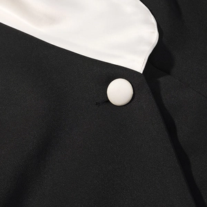 Détail du col en V contrasté avec revers en satin et boutons recouverts de tissu