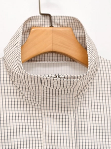 Détail de la veste à col montant avec motif à carreaux noir et blanc et fermeture éclair