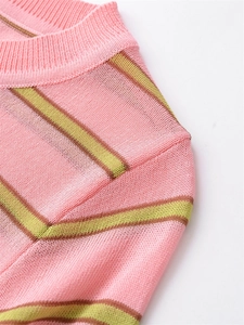 Close-up of pink knit sweater showing yellow stripes and ribbed texture detailing