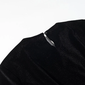Close-up of black velvet top featuring a teardrop cutout and button closure detail
