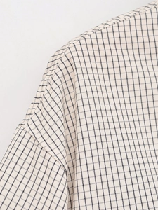 Détail du tissu en nylon beige à carreaux avec coutures précises et finition de l'épaule