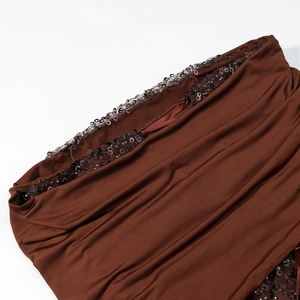 Detailed macro view of dark brown ruched knit fabric with sparkling sequin trim accents