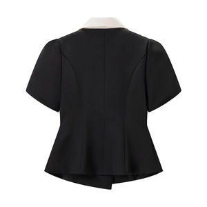 Détail de l'ourlet à basque et de la taille d'une veste de costume noire et blanche