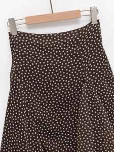 Detailed view of dark brown polka dot skirt fabric with lightweight draping and high waist