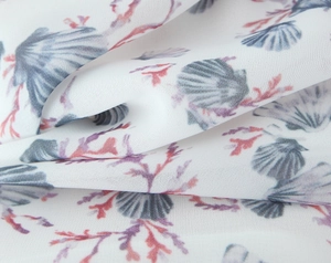Close-up of floral chiffon fabric with delicate seashell and coral prints for women dress