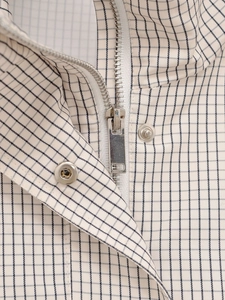 Détail de la fermeture éclair métallique et du bouton-pression sur la veste en nylon