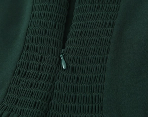 Détail de robe vert foncé montrant la texture élastique froncée et le zip invisible