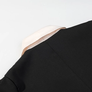 Détail du revers en V avec coutures précises sur un haut à manches courtes contrasté
