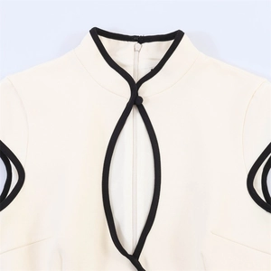 Detail von Stehkragen mit Tropfenausschnitt und schwarzer Paspel am Kleid