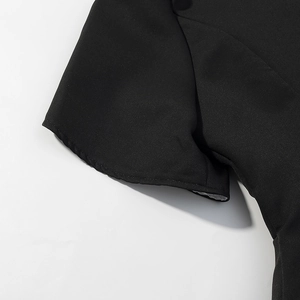 Détail de la manche en tissu noir lisse avec coutures de précision et bord ourlé