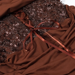 Detail of brown evening dress with metallic sequins and cross-tie satin ribbon bow