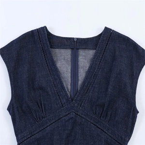Détail d'une robe en denim à col en V avec dentelle noire et fermeture éclair au dos