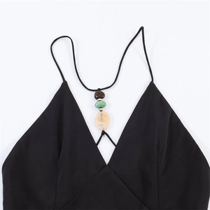 Detail of deep V-neckline with decorative natural stones on black sleeveless dress