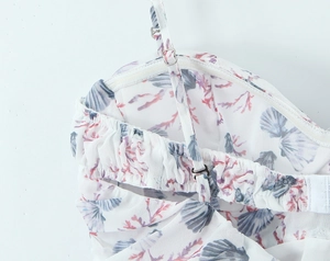 Detail of adjustable straps and elastic smocked back on seashell print summer dress