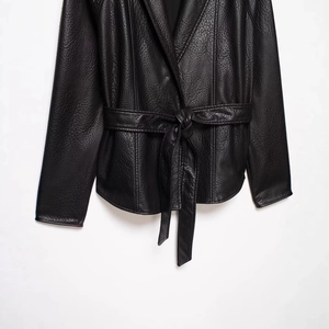 Women's black faux leather jacket with belted waist and textured finish