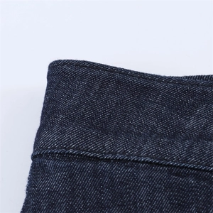 Dettaglio delle doppie cuciture e della lavorazione in vita degli shorts in denim blu