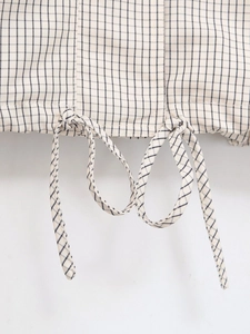 Détail du cordon de serrage sur l'ourlet de la veste en nylon avec motif à carreaux