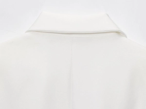 Detail shot of white linen blend blazer featuring classic lapel collar and neat stitching