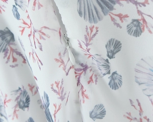 Detail of invisible zipper on floral print dress with ocean pattern and smooth stitching