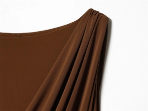 Détail macro de la robe marron montrant des plis froncés et une texture de tissu lisse