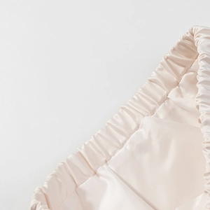 Vue macro des coutures de la taille élastique sur une jupe en satin champagne
