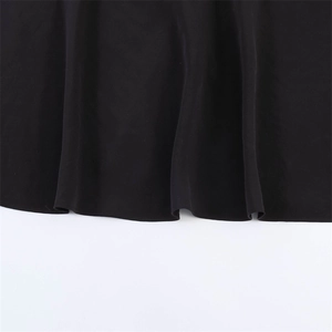 Detail shot of the black dress hemline featuring professional stitching and smooth drape