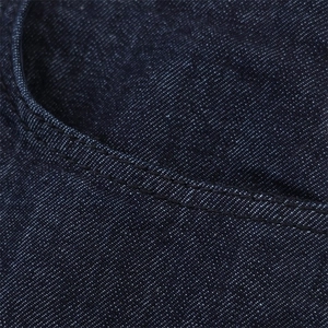 Dettaglio macro della tasca in denim blu scuro con doppie cuciture di alta qualità