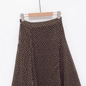 Polka dot high waisted asymmetric skirt in brown chiffon material on wooden hanger