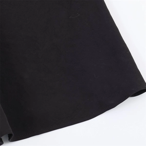 Detail of the high-quality stitching and fabric texture on a black bodycon dress hem