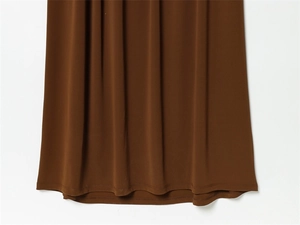 Détail de l'ourlet de la robe marron en tissu soyeux avec coutures à double aiguille soignées