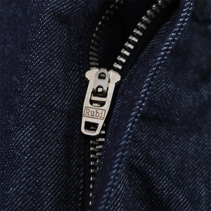 Dettaglio macro della cerniera in metallo su tessuto denim blu scuro con cuciture