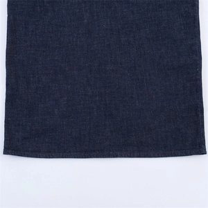 Gros plan détaillé de l'ourlet d'une robe en jean bleu foncé avec une couture plate soignée