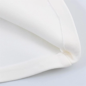 Gros plan détaillé du tissu de la robe blanche montrant les coutures de haute qualité