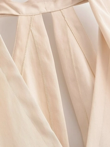 Détail macro du tissu tissé beige avec texture sergée et coutures du col licou