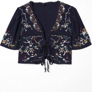 Navy blue embroidered crop top featuring a deep V-neck, bell sleeves, and front tie closure