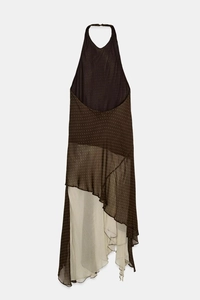 Detail of dark brown halter neck dress with white polka dots and asymmetric ruffled hem