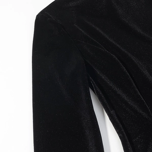 Detailed macro view of black velvet fabric with delicate lace stitching on the shoulder