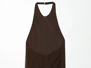 Detail of dark brown polka dot halter neck dress with plunging V-neck and back fastener