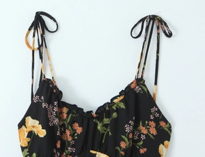 Close-up of floral print dress with ruffle neckline and tie-up ribbon shoulder straps