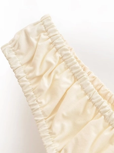 Détails du tissu en coton crème avec taille élastiquée froncée et coutures de précision