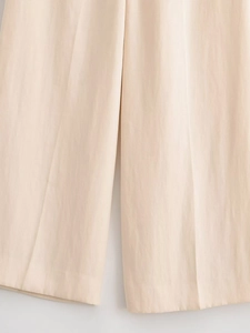 Gros plan détaillé sur la texture du tissu et les coutures du pantalon large beige