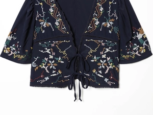 Detail of navy crop top with colorful ethnic floral embroidery and front tie closure