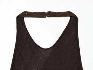 Close-up of halter-neck dress with white polka dots on dark brown fabric and button closure