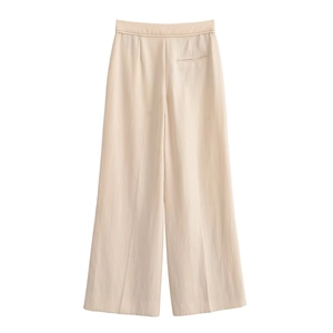Détail du pantalon beige à taille haute et jambes larges avec poche passepoilée au dos