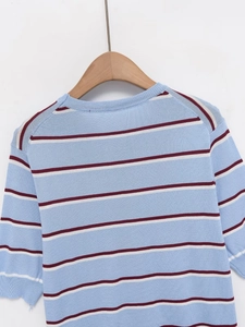 Close-up of knit fabric texture with red, light blue and white stripes on a wooden hanger